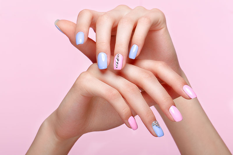 Beautiful,Pink,And,Blue,Manicure,With,Crystals,On,Female,Hand.